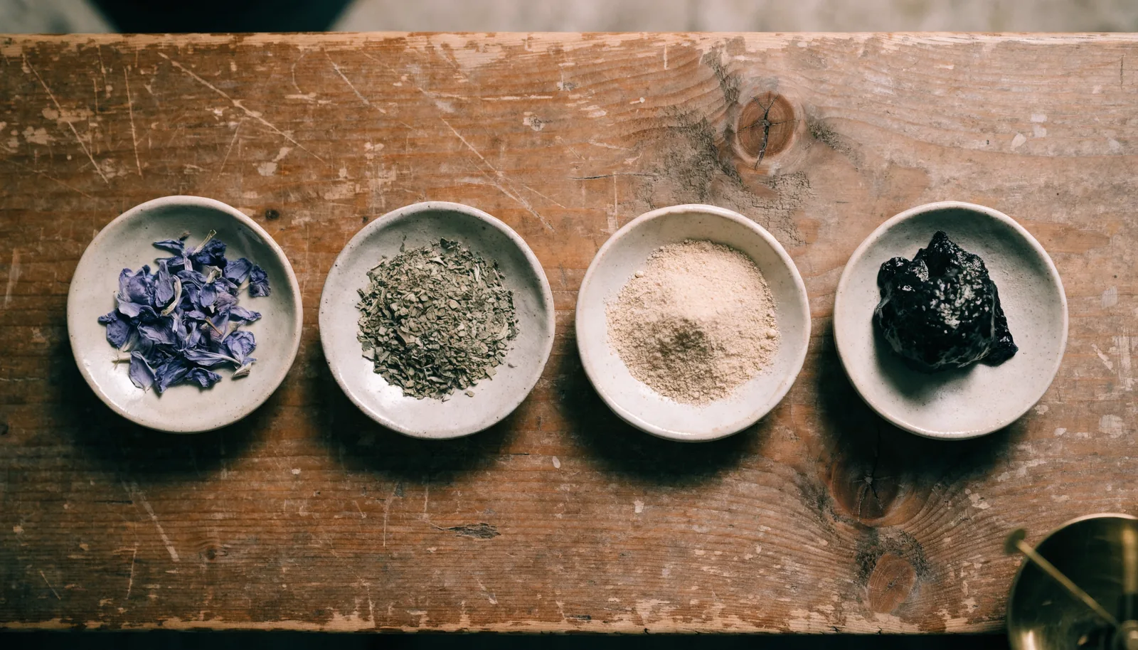 Ceramiczne miseczki z płatkami blue lotus, suszonym zielem kanny, proszkiem ekstraktu i żywicą